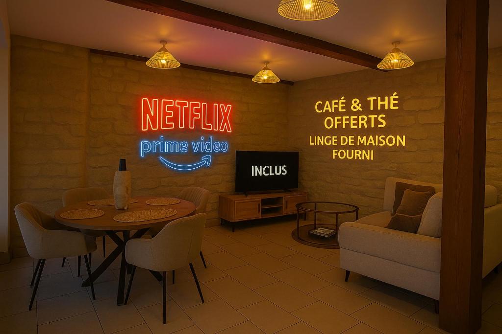 een restaurant met een tafel, stoelen en een neonreclame bij Cœur de Villers in Villers-Saint-Paul