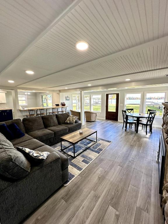 a living room with a couch and a table at Lakefront Escape Dock Fire Pit Sleeps 14 in Gaylord