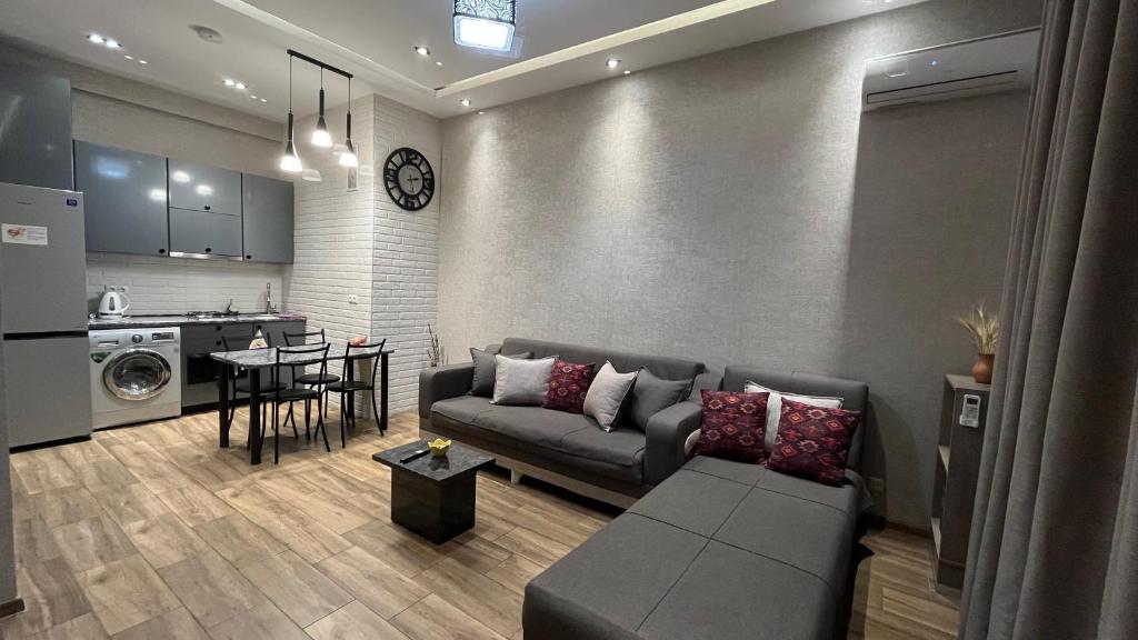 Una sala de estar con un sofá y una cocina. en Rustaveli Modern Apartment Center of Tbilisi, en Tiflis