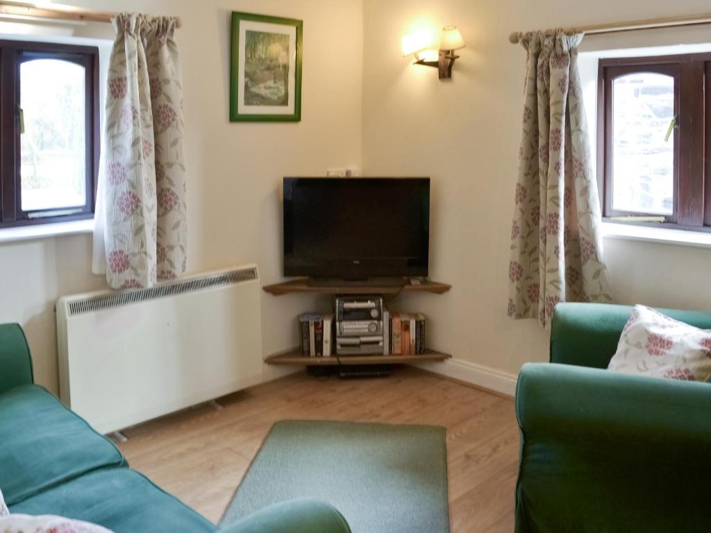 a living room with a couch and a flat screen tv at Demelza in Launceston