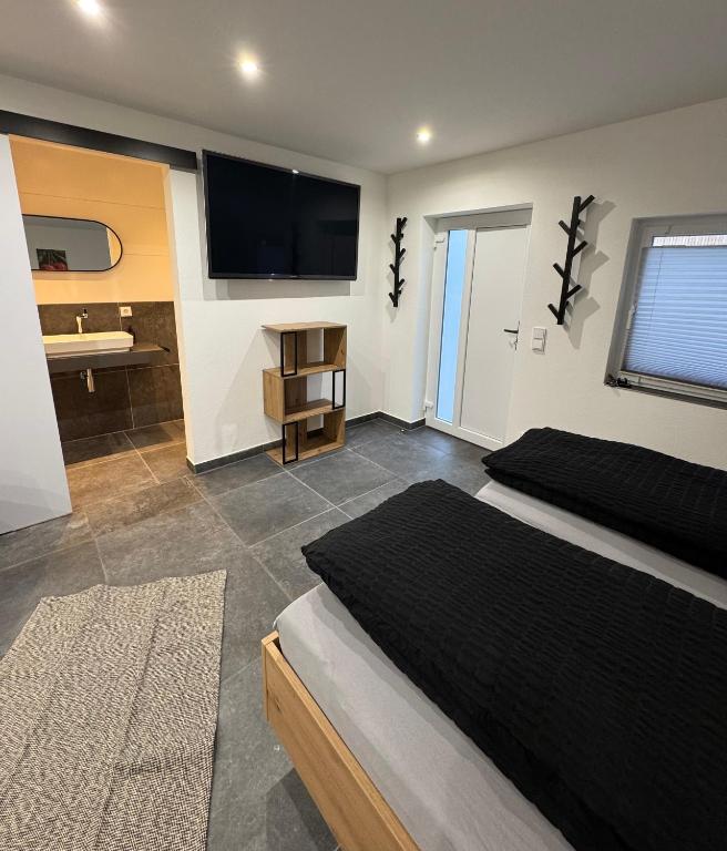 ein Schlafzimmer mit Bett und Flachbildfernseher in der Unterkunft Ferienwohnung Tee - Time - Lodge und Kirsch - Kiste in Momlingen