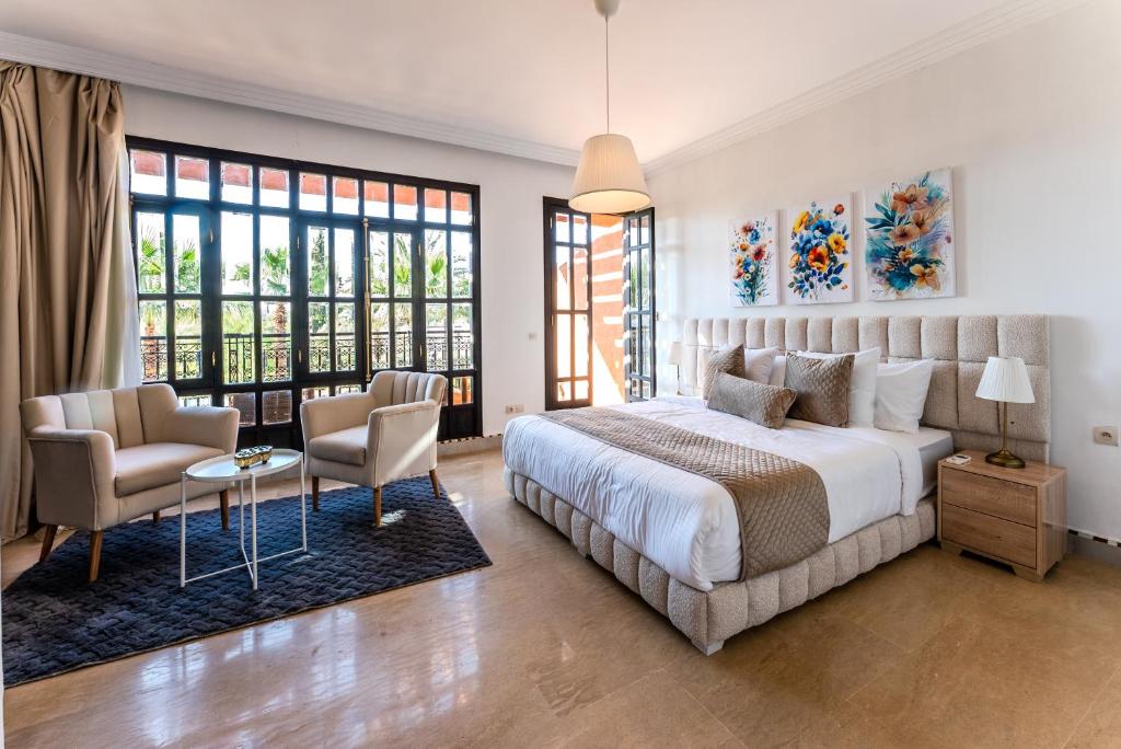 a bedroom with a large bed and two chairs at MVIEW Villas in Marrakech