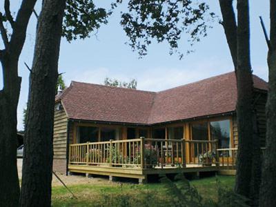 a house with a large deck in the yard at The Old Packhouse in Steyning