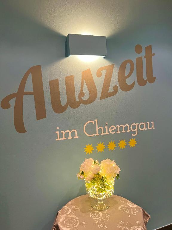 a vase with flowers on a table with a sign at Auszeit im Chiemgau in Rottau