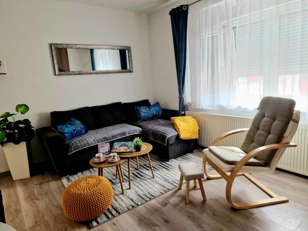 a living room with a black couch and a table at Apartman Relax in Slavonski Brod