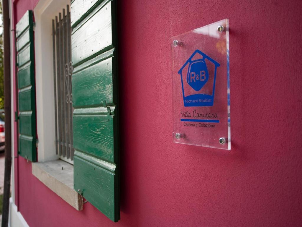 una puerta con una señal en el lateral de un edificio en Villa Camurana, en Medolla