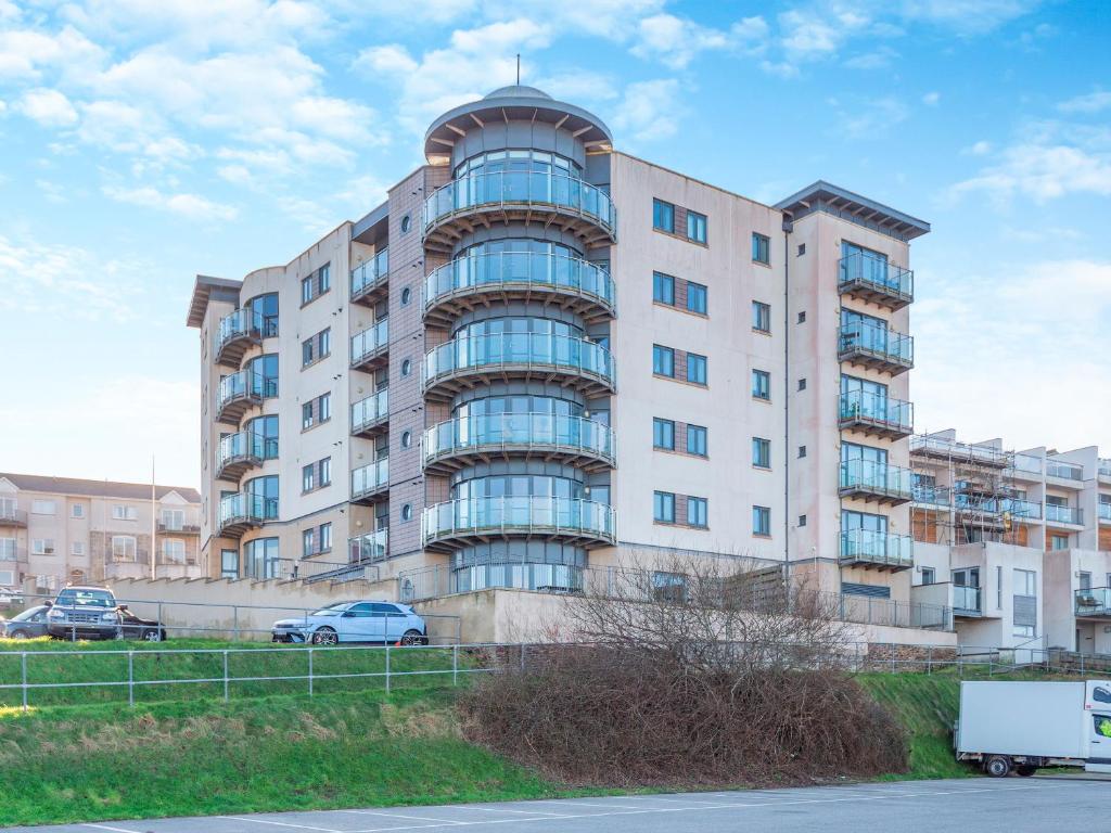 een groot appartementencomplex met auto's voor het gebouw bij 10 Horizons in Newquay