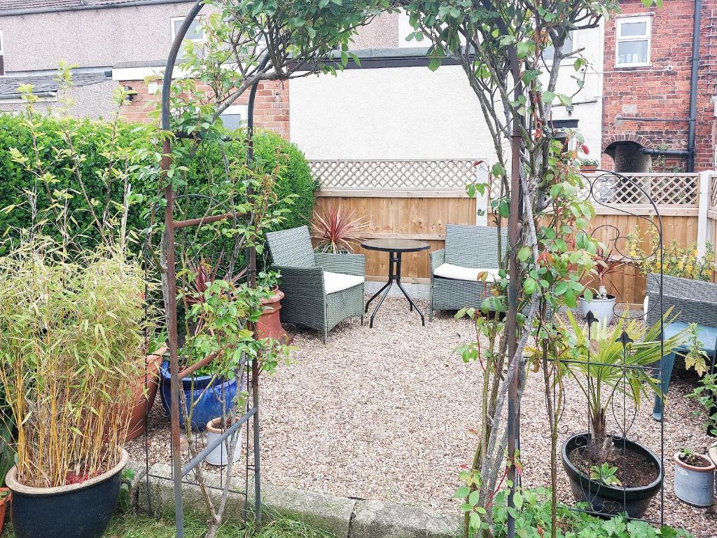 a garden with a table and chairs and plants at Amberley Cottage in Alfreton