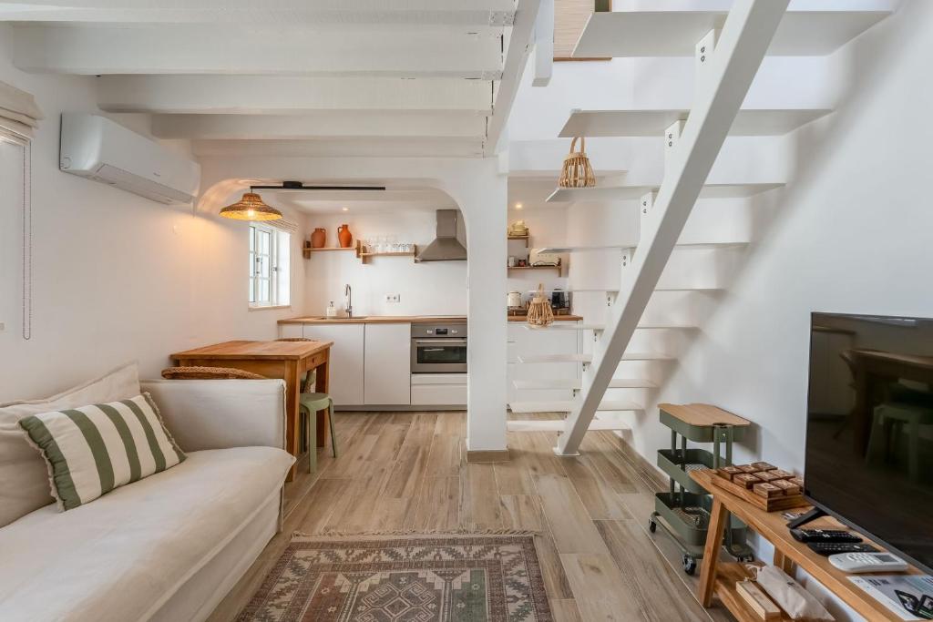 a living room with a white couch and a tv at Brisa do Sul in Porches