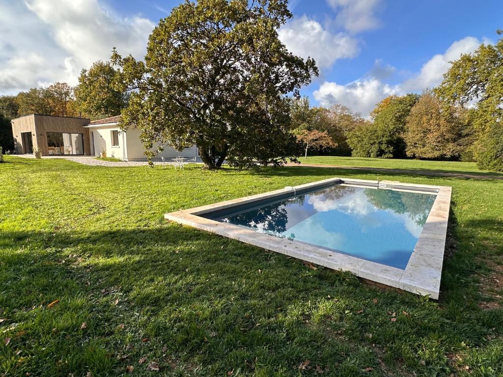 a swimming pool in the middle of a grass field at Villa Pavone in Angoulême