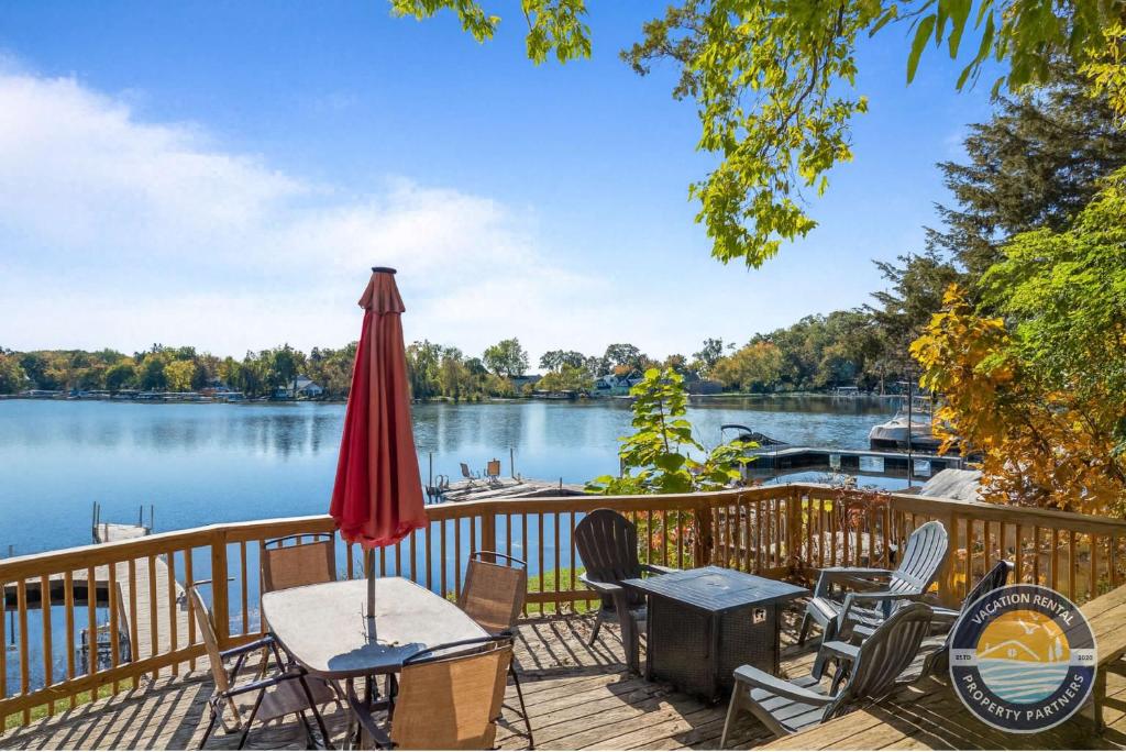 a deck with chairs and an umbrella next to a lake at 405 Waldeck Dr in Twin Lakes
