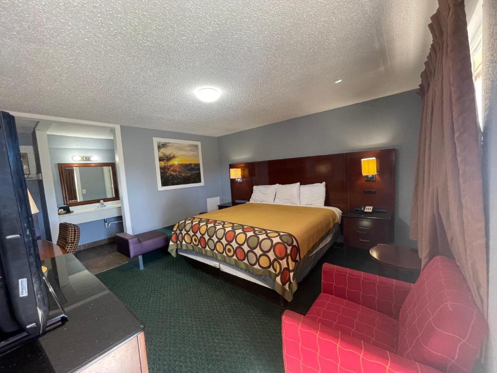 una habitación de hotel con una cama y un sofá en Western Capri Motel, en Tulsa