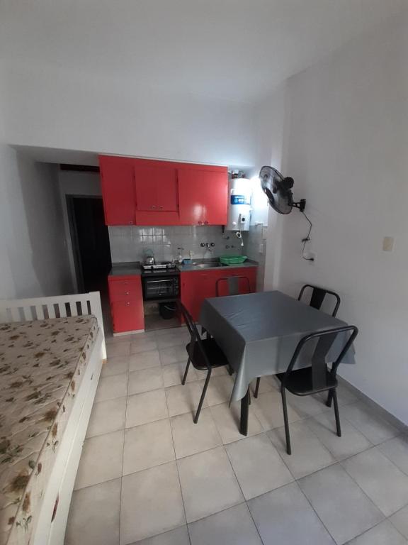 een keuken met rode kasten en een tafel en stoelen bij Ikigai Departamento in Santa Teresita