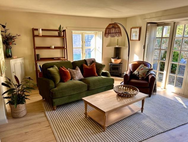 a living room with a green couch and a coffee table at The Barn at The Manor in Cole, Bruton in Cole