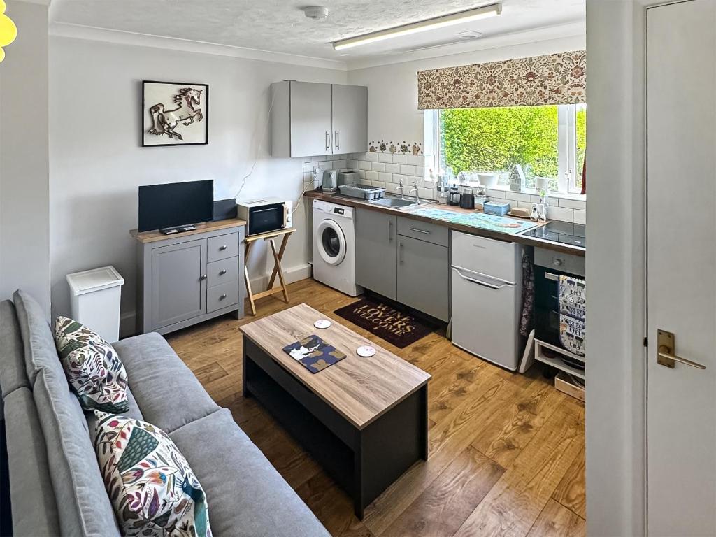 a kitchen and living room with a couch and a table at The Nest - Uk46879 in Woodbury