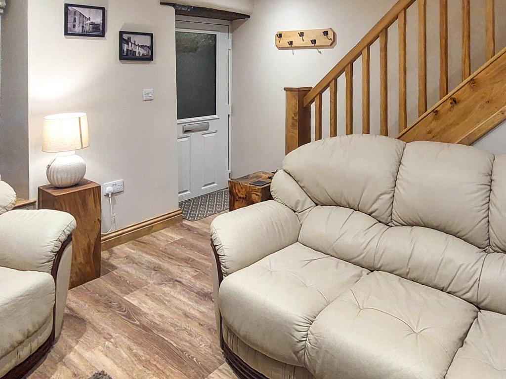 ein Wohnzimmer mit einer Couch und einer Treppe in der Unterkunft 13 Doomgate Cottage - Uk45056 in Appleby