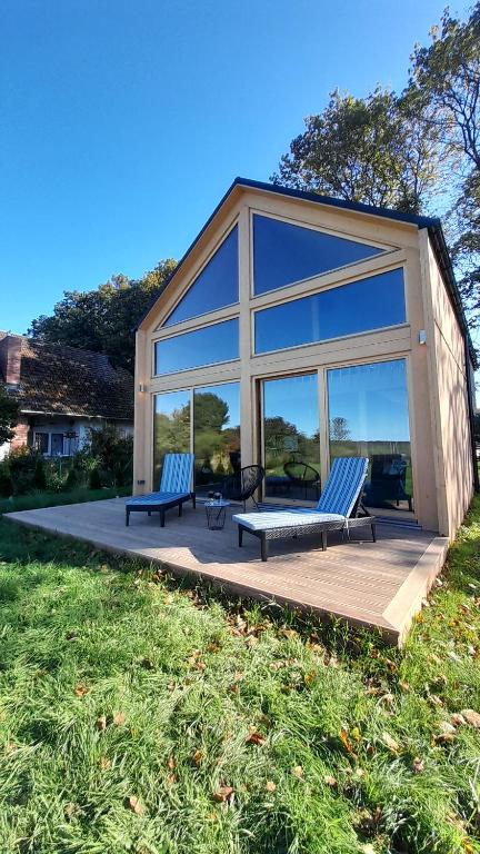 een paar bankjes op een terras bij een huis bij Villa Leone in Nowe Warpno