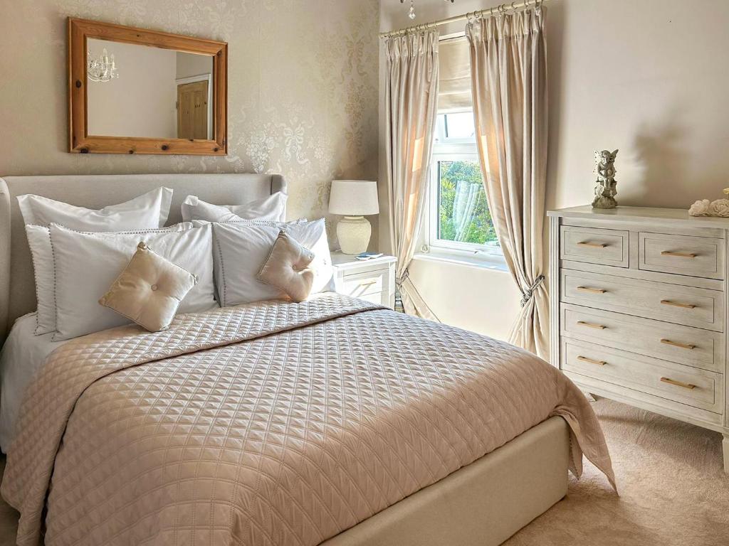 une chambre avec un lit, une commode et un miroir dans l'établissement Lavender Cottage, à Frinton-on-Sea