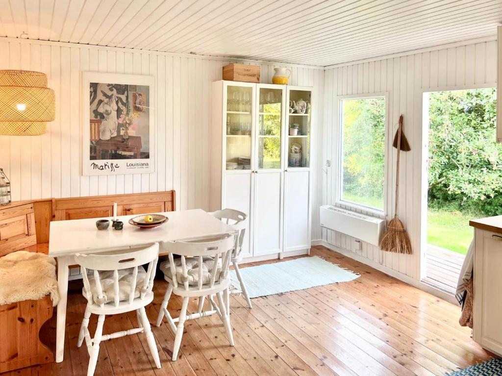 a kitchen with a white table and chairs at Get Close To Nature And The Starry Sky in Stege