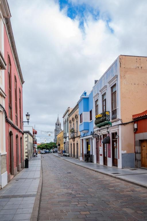 an empty street in a town with buildings at La Centenaria 1920 in Telde
