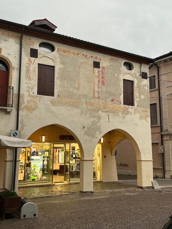 un vecchio edificio con archi di fronte a un negozio di Casa Sorgata a Noale