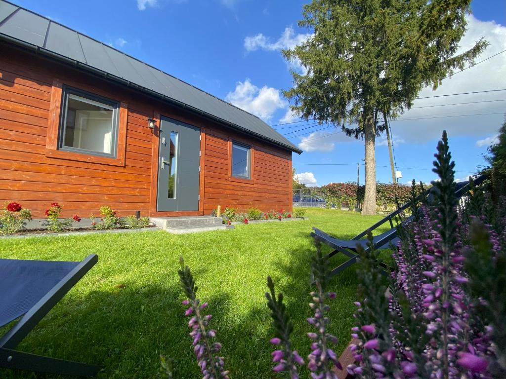 a wooden house with a yard with flowers at Domek-noclegi in Sandomierz