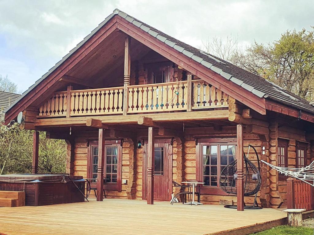 a log cabin with a balcony and a deck at Ty Afal - Uk42099 in Carno