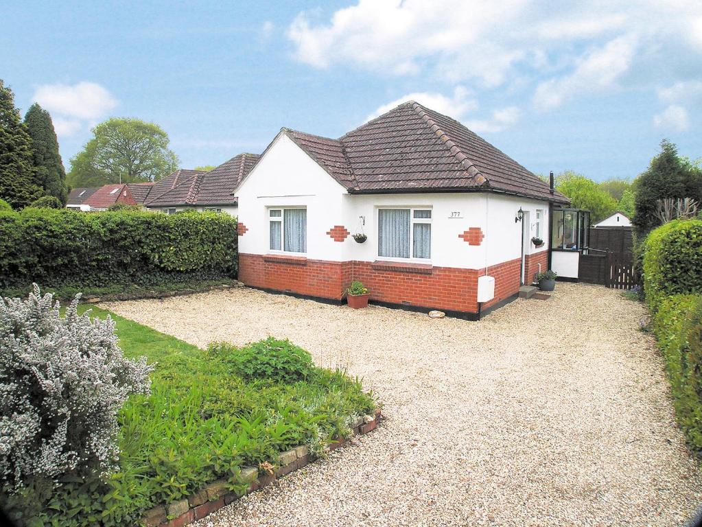 a white house with a brown roof at Oak Lodge in Longham