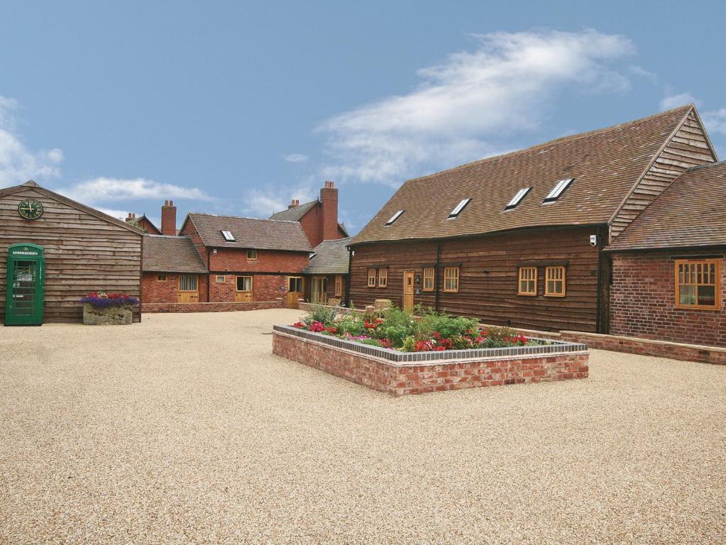 a group of buildings with flowers in a courtyard at The Olde Granary - E4298 in Halston