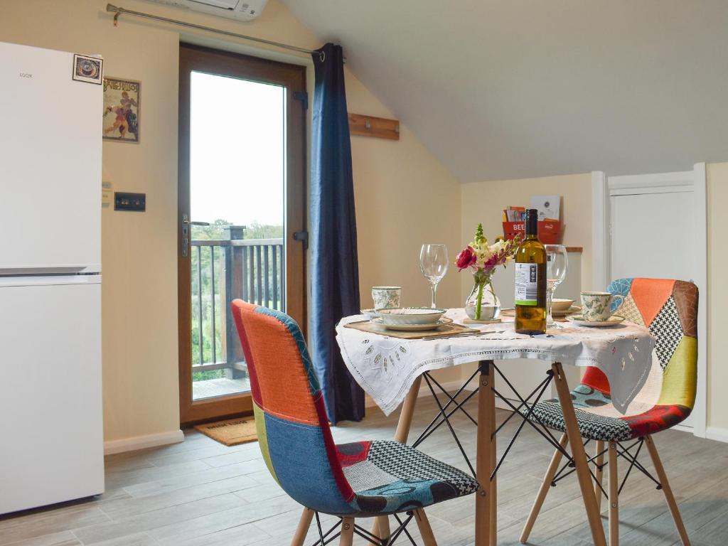 a dining room with a table and chairs at Moorhens in Herstmonceux
