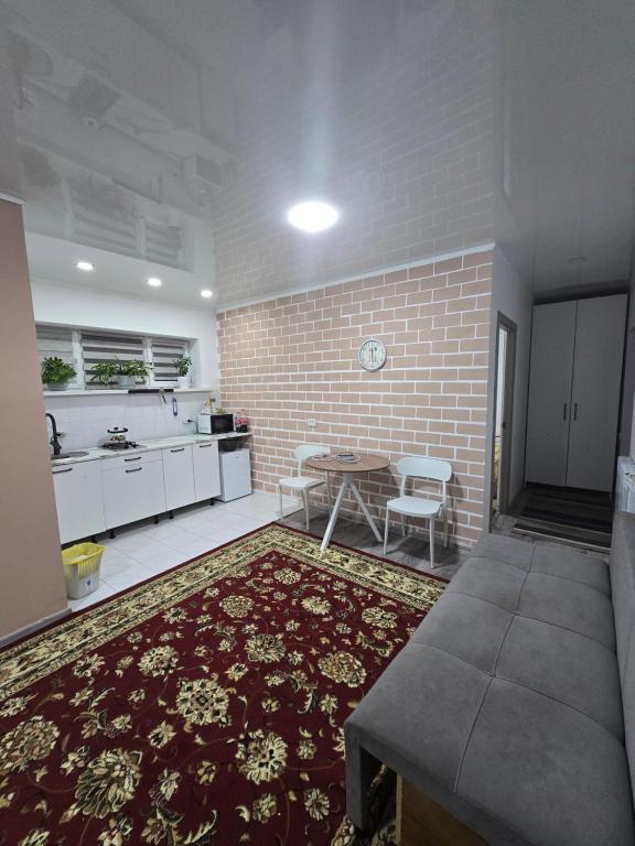 a kitchen with a table and a brick wall at Guest House in Talghar