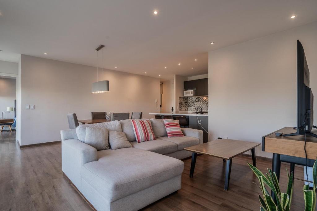 a living room with a couch and a table at Elegante apartamento 3 recamaras Juriquilla in Juriquilla
