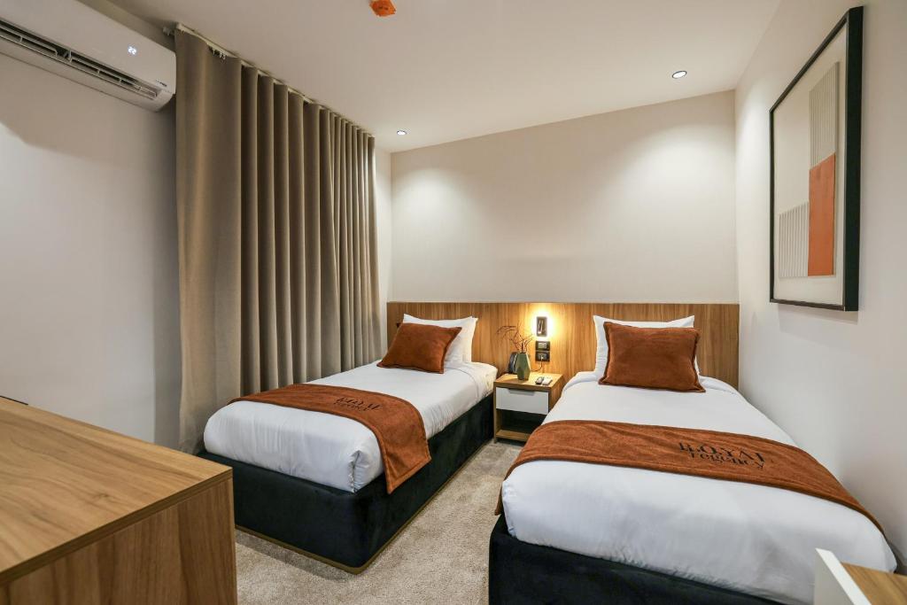 a hotel room with two beds and a television at Royal Regency Eg Hotel in Cairo