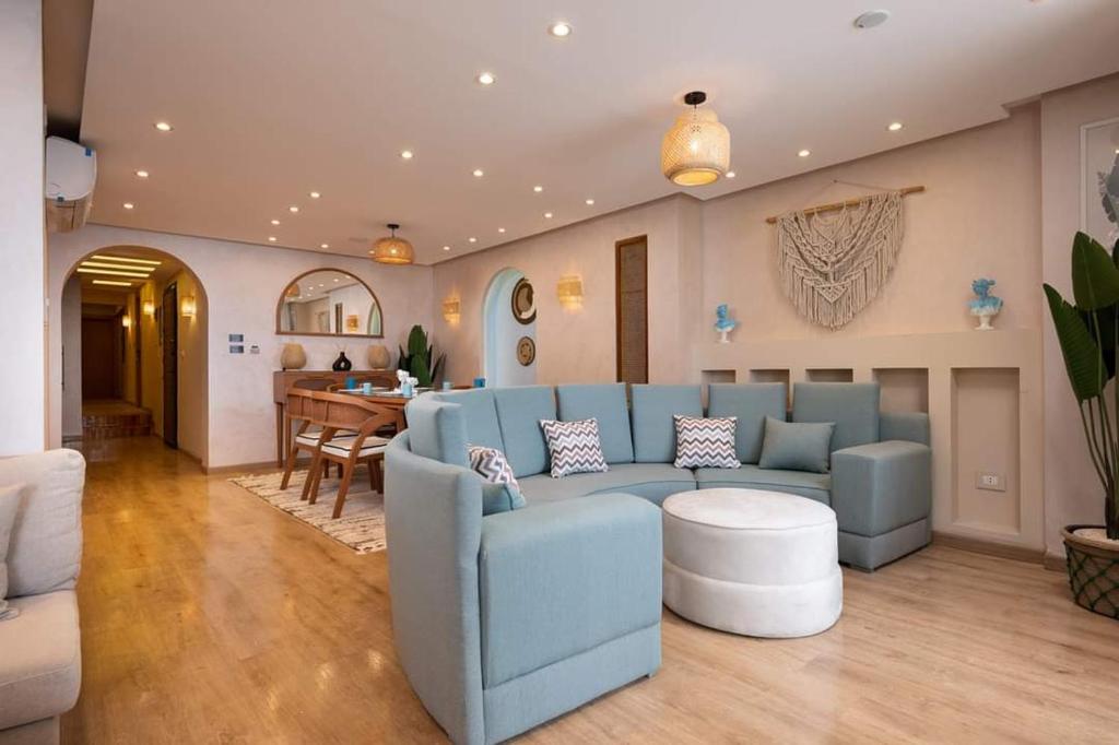 a living room with a blue couch and a table at Al-Saraya Homes in Alexandria