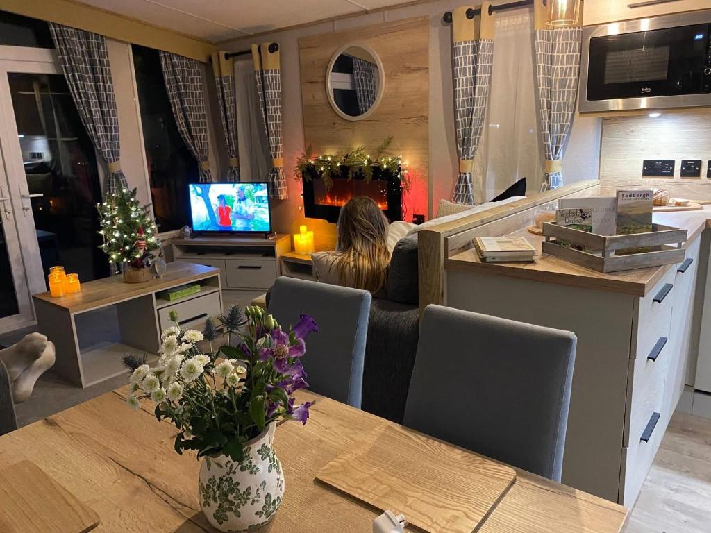 a woman sitting at a table in a room at Sheepfold lodge in Sedbergh