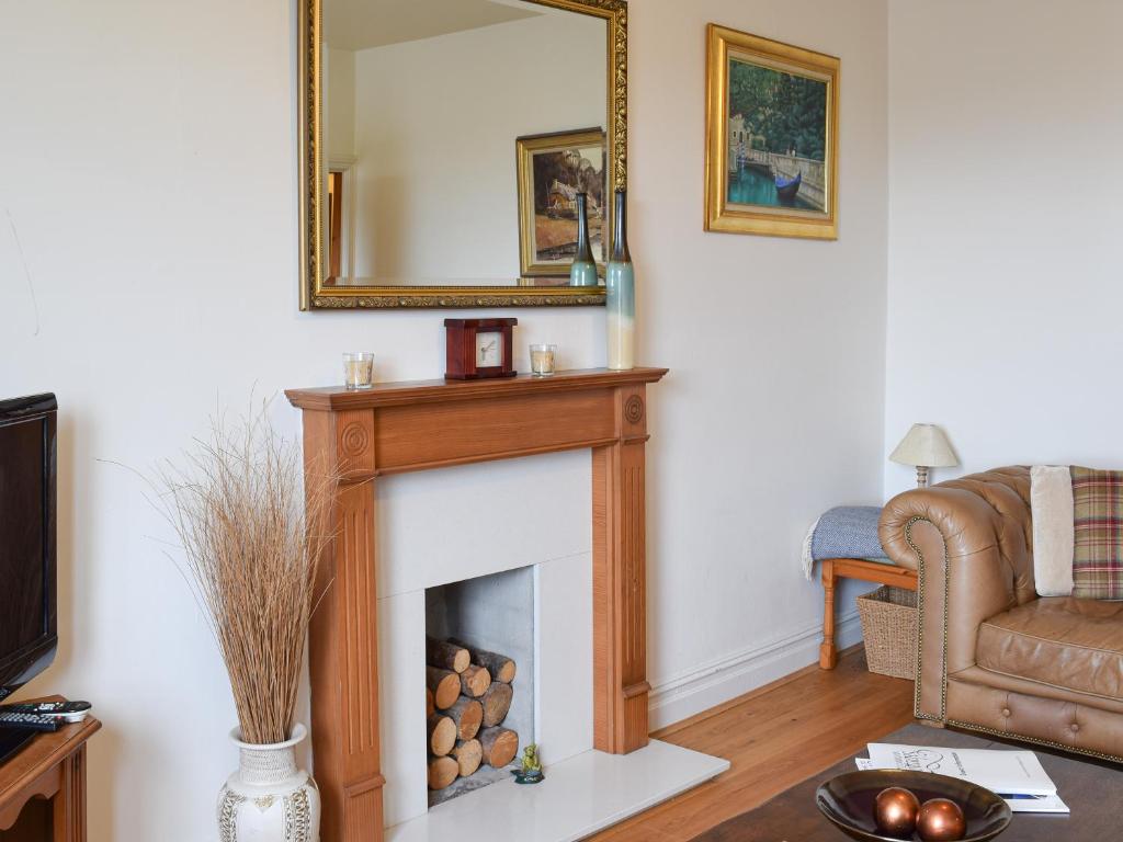 a living room with a fireplace and a mirror at Lake View Apartment in Bowness-on-Windermere