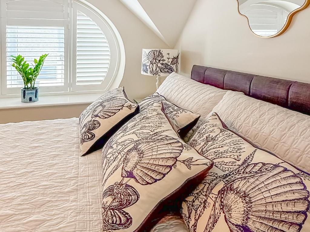 een bed met kussens erop in een slaapkamer bij The Police Station - Uk45642 in Silloth