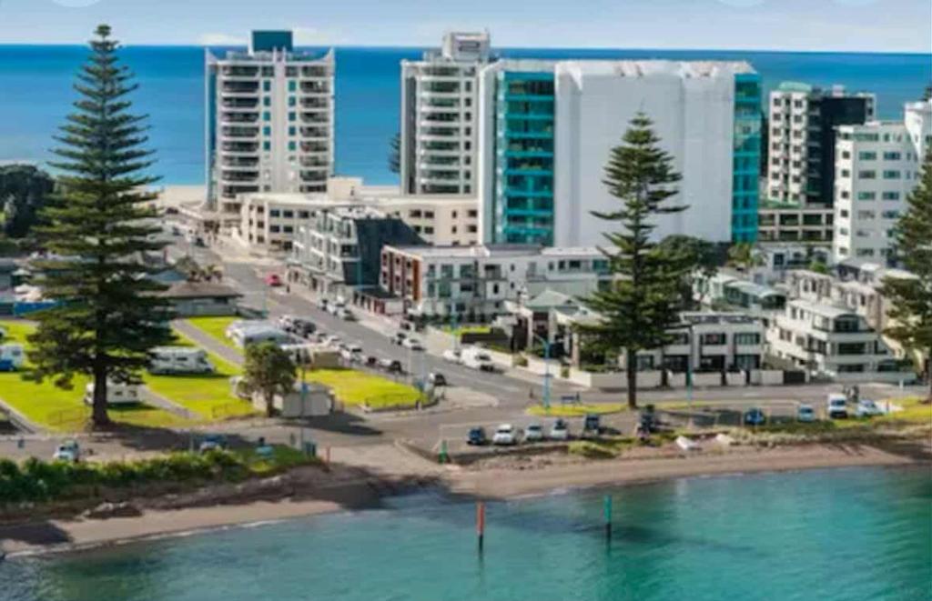 an aerial view of a city with a beach and buildings at Luxury Beach Escape - 6 Adams Ave Mt Maunganui in Mount Maunganui