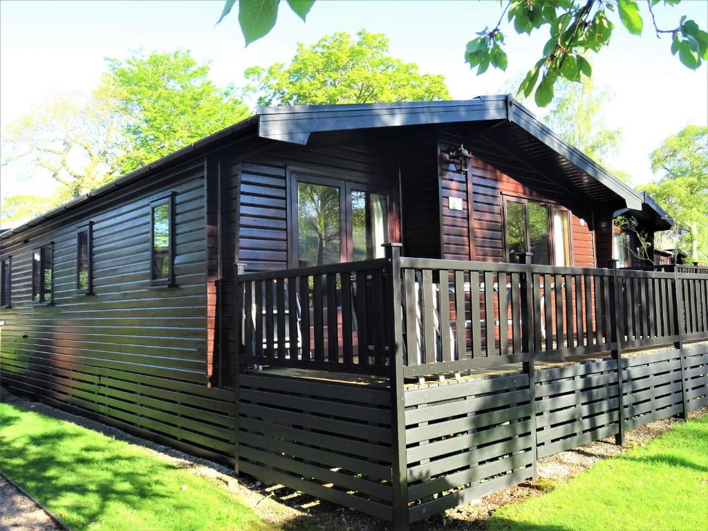 a log cabin with a porch and a deck at Bewick Lodge in Keswick