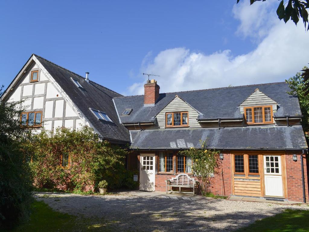 an old house with a black roof and a driveway at Celyn in Montgomery