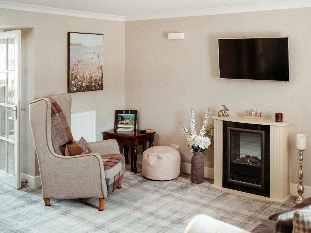 a living room with a fireplace and a flat screen tv at Drumwherry By The Sea in Monreith