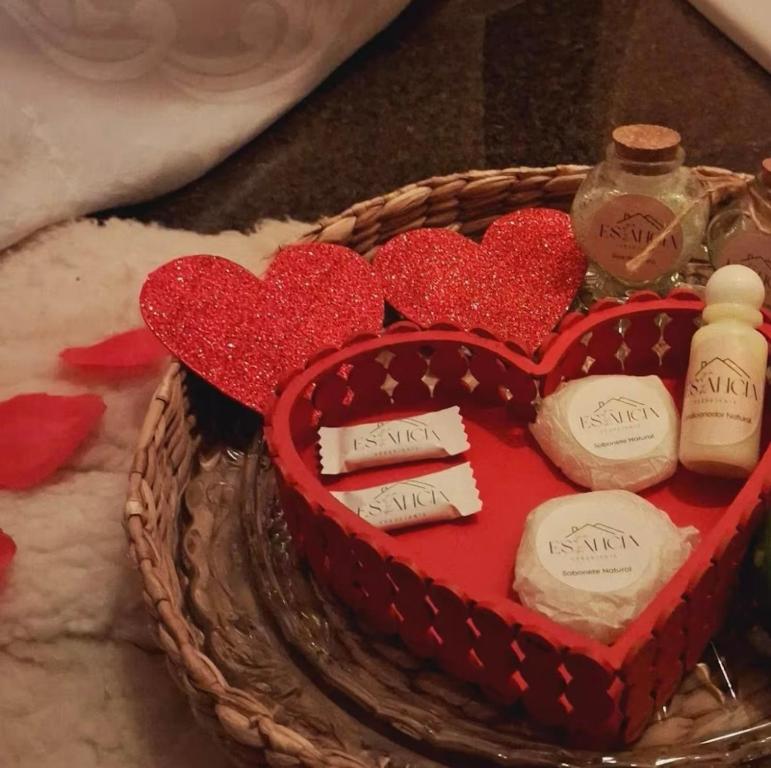 a red heart shaped cake with bottles on top at Chales Estância Verdejante in Sapucaí-Mirim