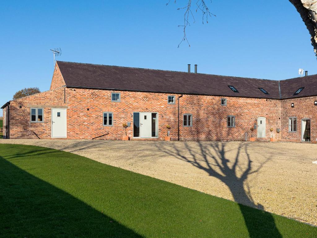 a brick building with a shadow of a tree at The Maddocks - Uk36311 in Whitchurch