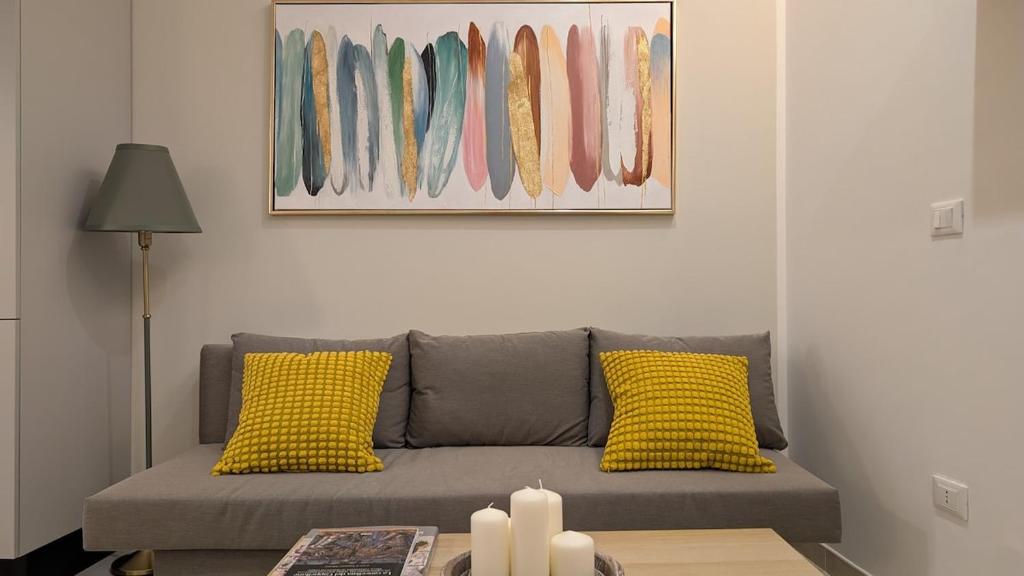 ein Wohnzimmer mit einem grauen Sofa und gelben Kissen in der Unterkunft La casa degli Archibugi in Sulmona
