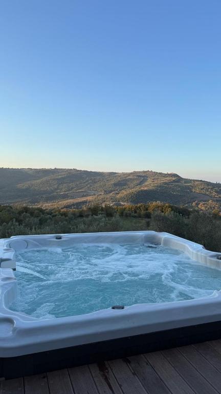 a hot tub sitting on top of a wooden deck at Casale il Gugnolo in Castiglione dʼOrcia