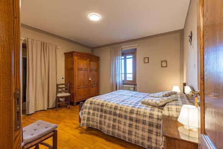 ein Schlafzimmer mit einem Bett, einer Kommode und einem Fenster in der Unterkunft Casale il Gugnolo in Castiglione dʼOrcia