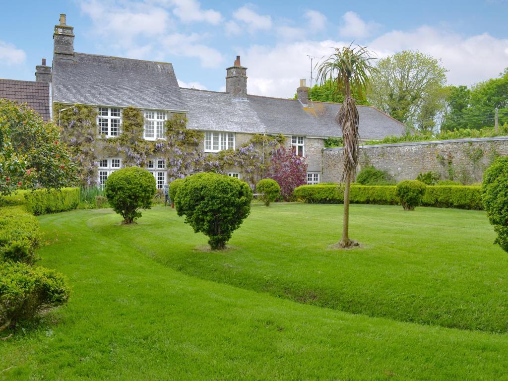 an old stone house with a green yard at Manor House in Uny Lelant
