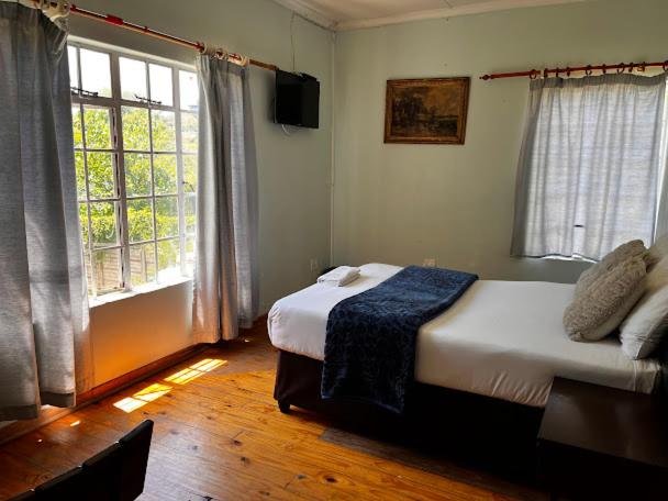 a bedroom with a bed and a large window at Evergreen guest house in Pietermaritzburg