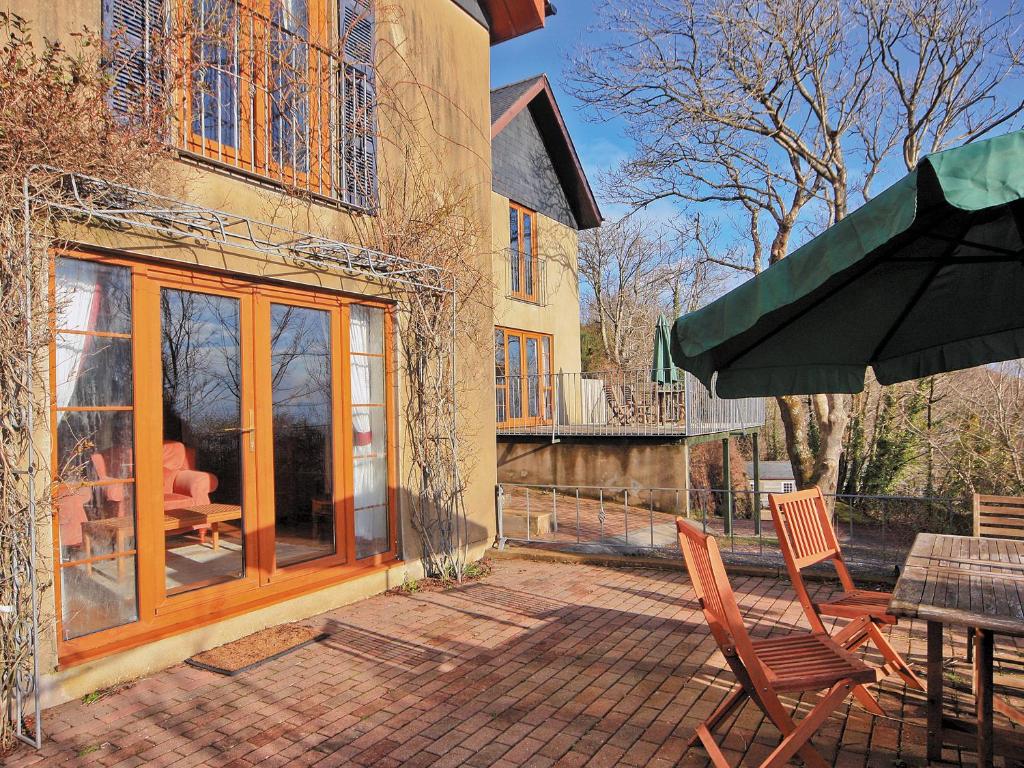 eine Terrasse mit Stühlen, einem Tisch und einem Sonnenschirm in der Unterkunft Coast View Cottage - Hw7745 in Pendine