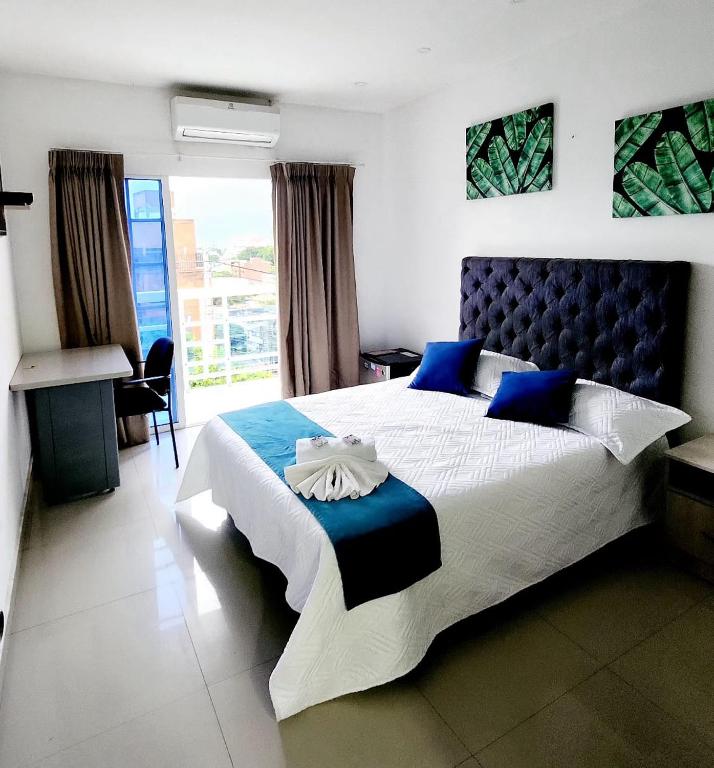 a bedroom with a large bed with a blue headboard at CHIPICHAPE INN in Cali